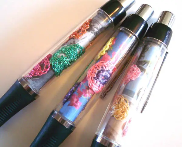For these, I crocheted tiny shells and circles out of Kreinik Tapestry #12 Braid and Japan #5 thread (both good weights for small motifs). I added some photos for the backdrop, and glued them all into the Kreinik Make-A-Pen.