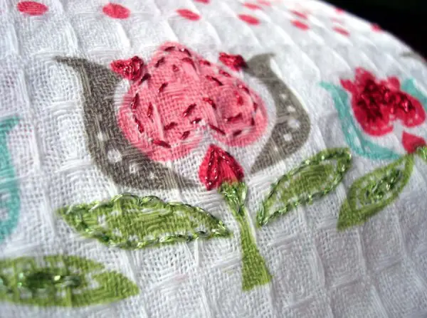 Sweet and soft metallic threads worked in basic backstitches add elegance to this dollar-store tea towel.