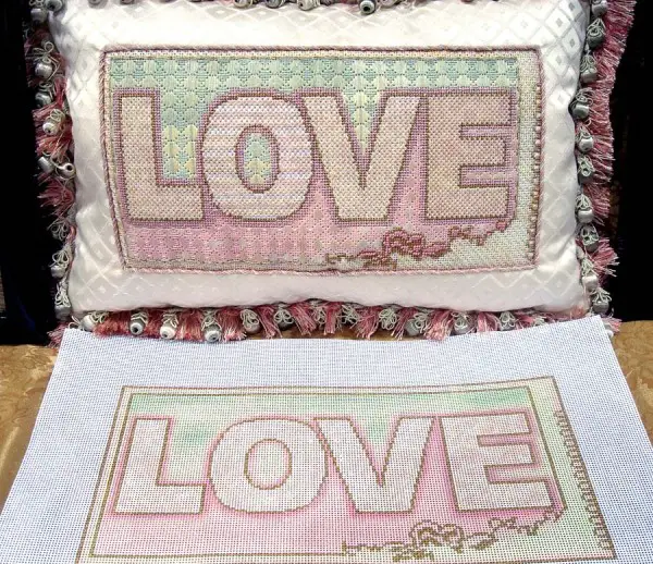 This design is a simple word painted on needlepoint canvas, but it is brought to textile life through a variety of threads and stitches. Design by Lani Silver of Lani's <a class=