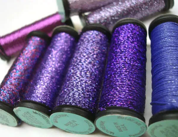 These gorgeous, rich shades of purple are in the form of Kreinik Braid. This brilliant thread is meant to be used alone (not used as a carry-along) to add a bolder metallic look to a design. Washable, dry cleanable, available in several sizes to suit different counts of fabric/canvas and different stitches. Explore more here: http://www.kreinik.com/shops/Metallic-Threads/