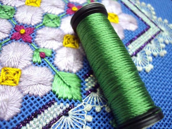 This needlepoint design by Mary Polityka Bush features Kreinik Silk Mori (the purple flowers) and Kreinik Silk Serica (the green leaves). To make the leaves, the Serica is separated, moistened with a slightly damp cosmetic sponge to remove the waves, and laid as a flat silk (for optimum sheen).