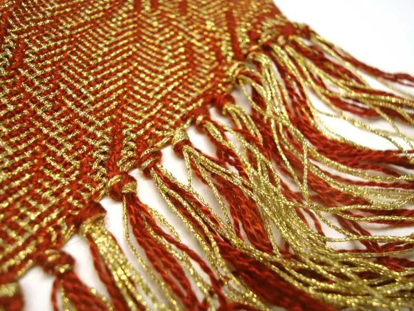 This is a classic pattern from DJE Handwoven's line, but remade using metallic threads. The look is so elegant, while the drape is still soft. Here, Deb used Kreinik Fine #8 gold Braid and an 8/2 Tencel for the rust color.