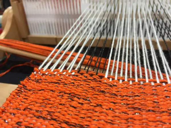 This is one of Doug Kreinik's weaving projects, worked using silk and metallic threads. He used Kreinik Braid in black for warp, and an orange/black combination for the weft. Love the way the metallic adds the "spice" of light to the design.
