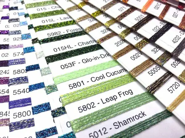 Get you a color card that can do both: show you the colors and the threads. Some simply show photos of color swatches. Go for the real thing. This is a Kreinik metallic thread color card. 