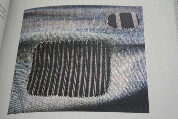 Beauty in mending, patterned pieces are used to cover holes in denim to mend and patch.