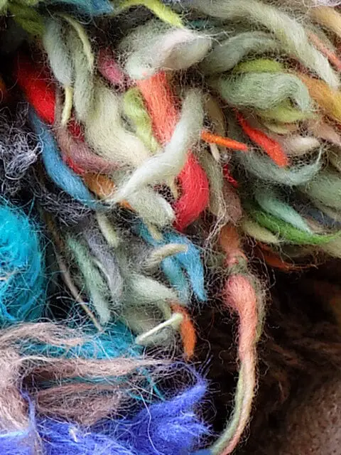 Using wool pompoms to create depth and structure within a textile