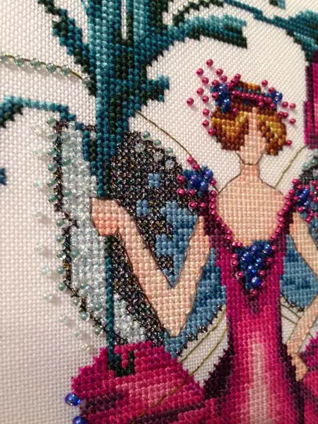 Zinnia is one of the Pixie Blossom designs in Mirabilia's cross stitch pattern line. Shades of wine in the dress stand out beautifully next to blue shades of cotton and Kreinik metallic threads (plus Wichelt Import beads).