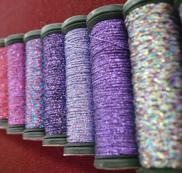 I love this photo, taken at the Kreinik thread factory, because it shows some of the variegated colors they make. It comes from an old thread display, but I believe all but the color on the far right are still produced.