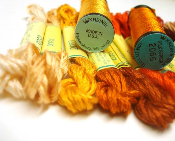 Two types of silk thread are shown here: Kreinik Silk Mori, a spun silk (the skeins) and Kreinik Silk Serica, a filament silk (the spools). You can see the difference in texture and sheen. From http://www.kreinik.com/shops/Silk-Threads/