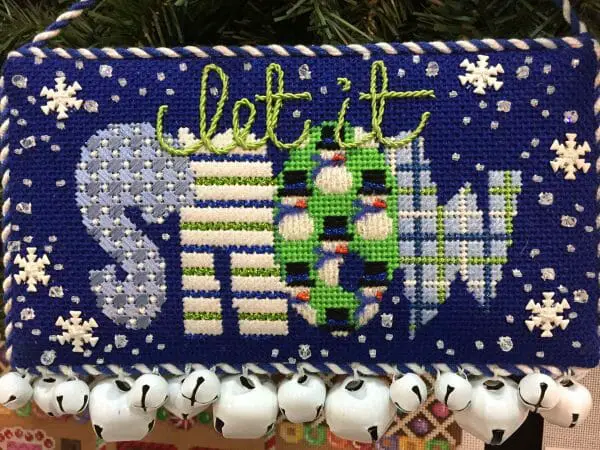 Stitching snow can make winter downright enjoyable. Play with metallic threads to create realistic looking snow, have fun with a variety of stitches, and create something beautiful this month. Canvas by Associated Talents needlepoint company.