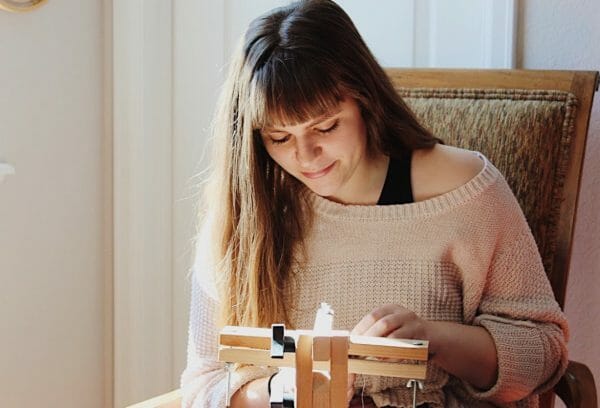 Carly Owens stitching at her frame.
