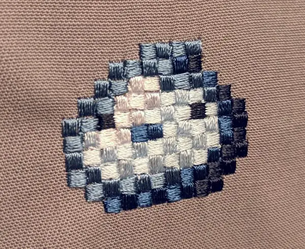 Finished Blue Slime Pixel Art Embroidery design by Erich Campbell seen from an angle
